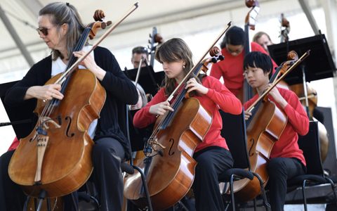 Young musicians and LSO members of the cello section on stage at BMW Classic 2026 during the performance of Louise Drewett's Four Dances